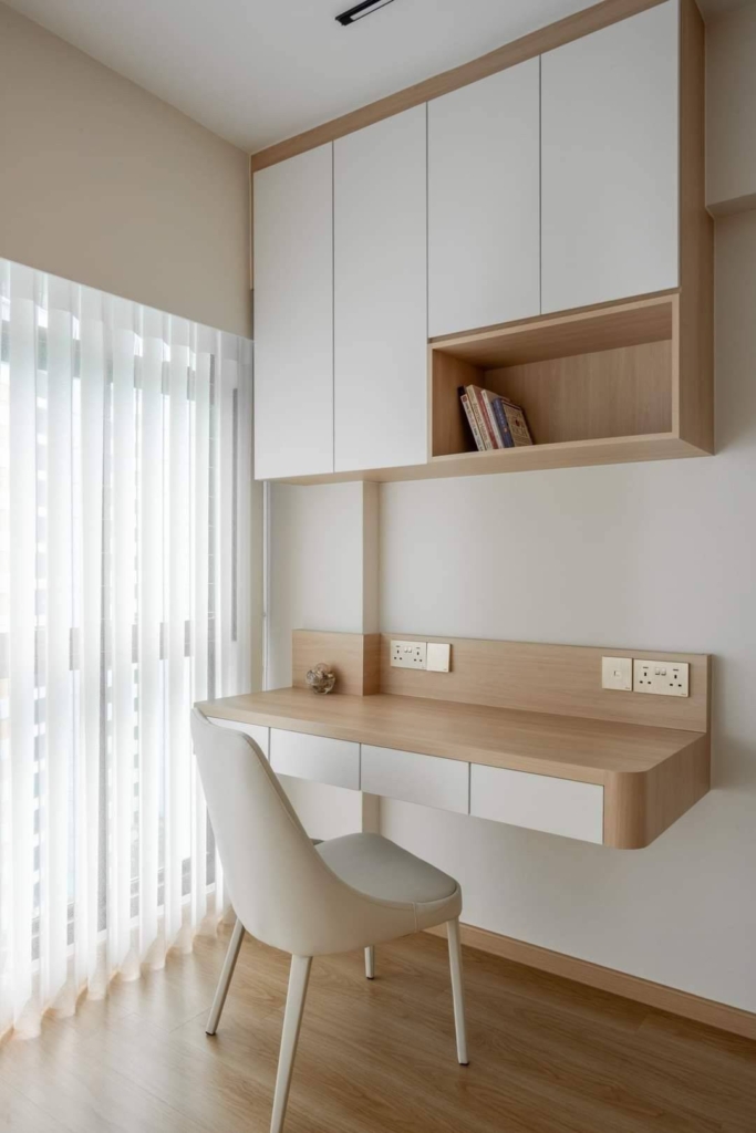 Space-saving study unit with floating desk and overhead cabinets in a modern minimalist apartment interior.